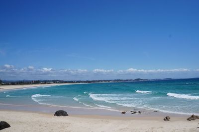 Scenic view of beach against blue sky