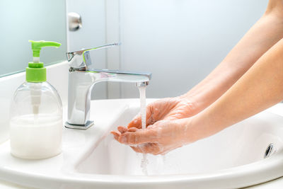 Midsection of woman in bathroom at home