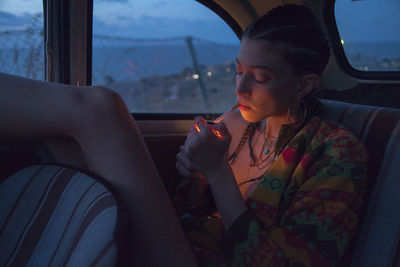 Midsection of woman sitting in car window