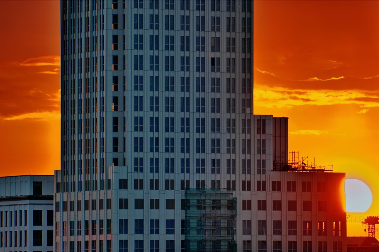 LOW ANGLE VIEW OF BUILDINGS AGAINST DRAMATIC SKY