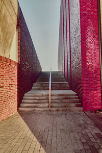 Empty alley amidst buildings against sky