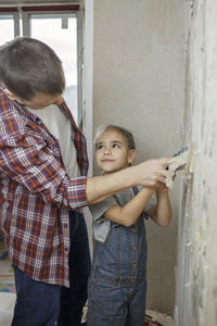 Father and daughter standing on doorway