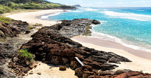 Rock formation on beach against sky