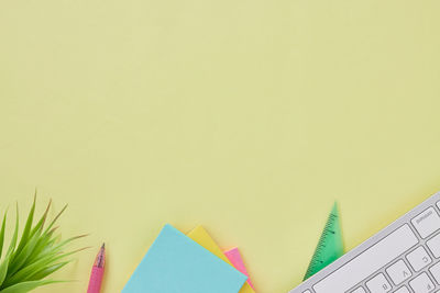 Close-up of multi colored paper on table against wall