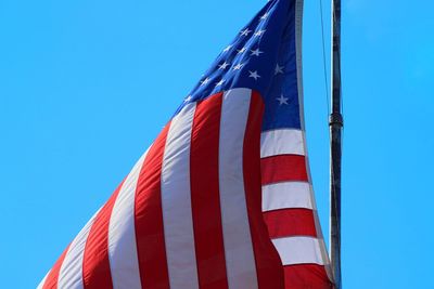 Low angle view of flag against blue sky