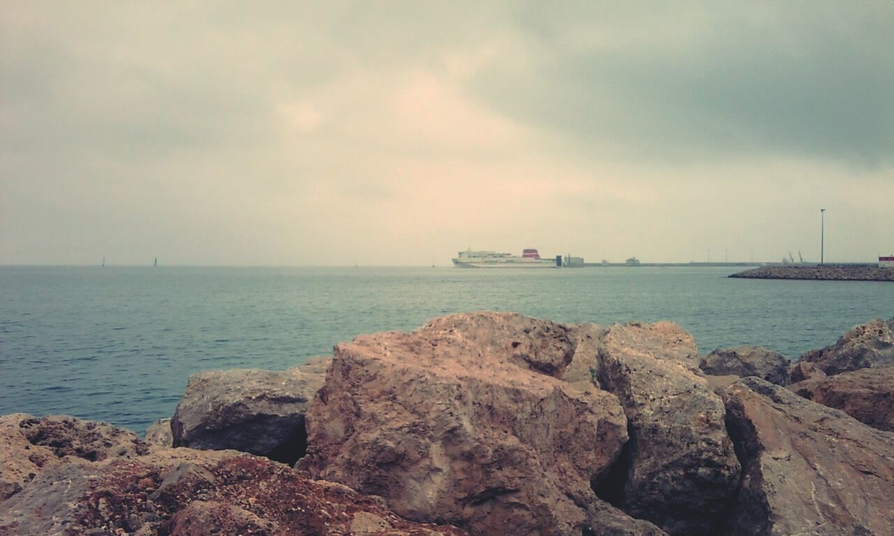 sea, water, horizon over water, sky, rock - object, scenics, tranquility, tranquil scene, beauty in nature, nature, cloud - sky, shore, rock, beach, idyllic, rock formation, transportation, nautical vessel, cloud, outdoors