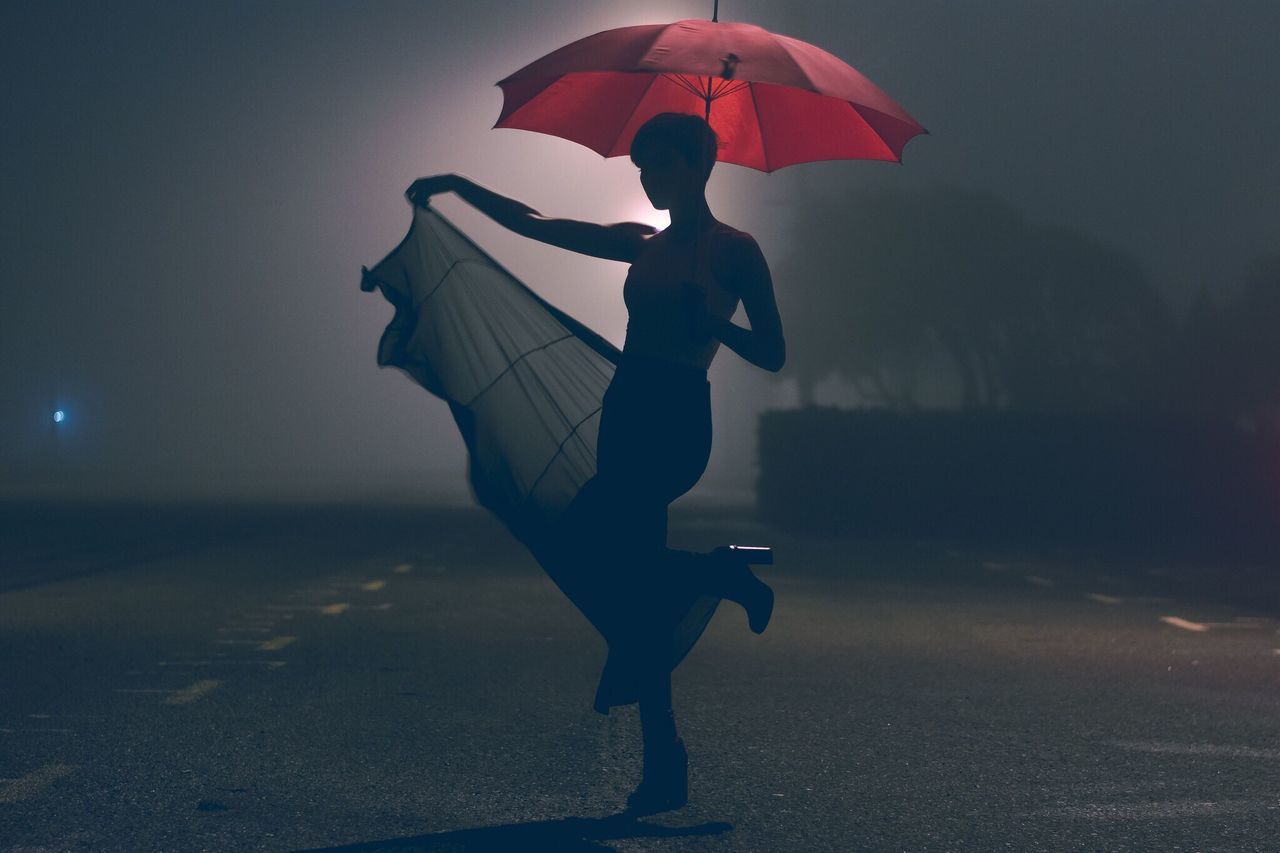 full length, lifestyles, leisure activity, red, walking, night, standing, street, silhouette, road, shadow, rear view, men, outdoors, motion, holding, umbrella, person