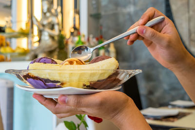 Close-up of woman eating fresh dessert at restaurant