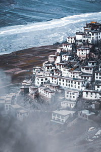 High angle view of buildings by sea during winter