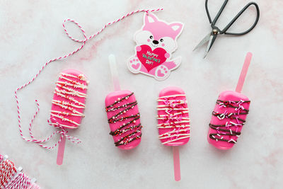 Homemade valentine cakesicle treats with a valentine card attached to one.