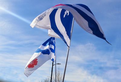 Low angle view of flag against blue sky