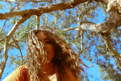 Low angle view of woman looking tree