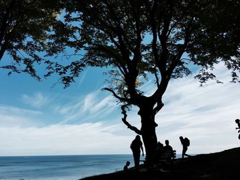 Silhouette of people standing by river