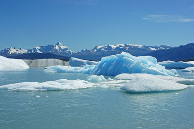 Scenic view of frozen lake against clear blue sky