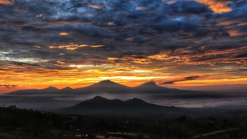 Scenic view of dramatic sky over silhouette landscape