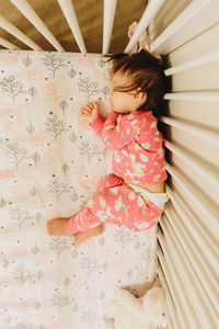 High angle view of girl sleeping on bed