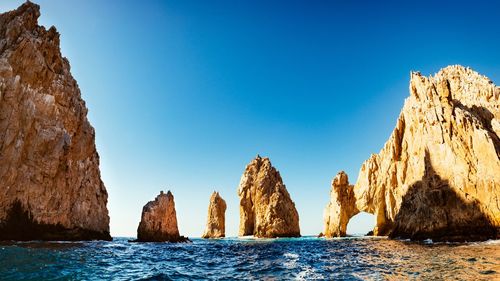 Rock formations in sea against sky