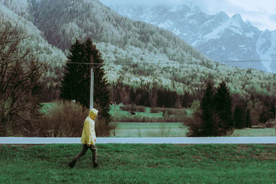 Side view of man walking on grassy field