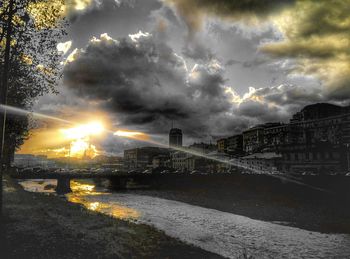 Bridge over river against cloudy sky