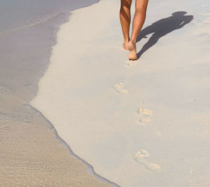 Low section of person walking on beach