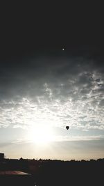 Silhouette of hot air balloons against sky during sunset