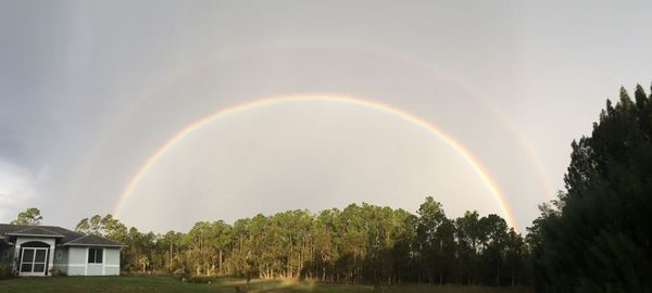 Scenic view of rainbow over building against sky