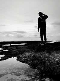 Rear view of man looking at sea against sky