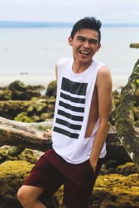 Portrait of young man standing on beach