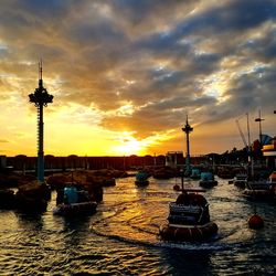 Sailboats in city at sunset