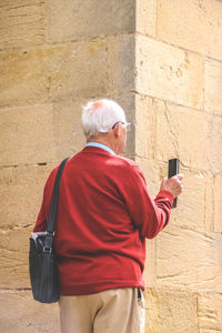 Rear view of man using mobile phone