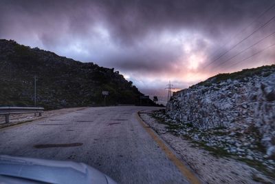 Road by mountain against sky