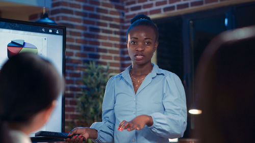 Portrait of young woman standing in office