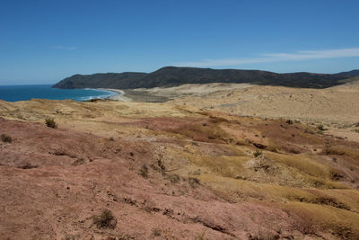 Scenic view of sea and mountains against blue sky