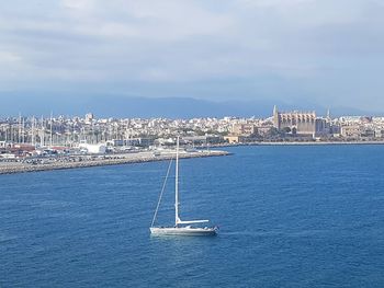 Sailboats in sea against sky