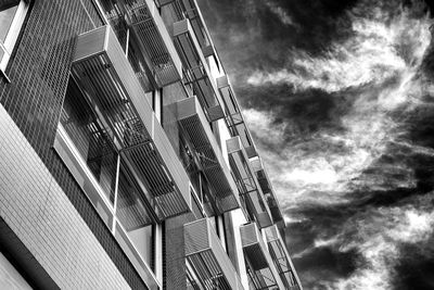 Low angle view of modern building against cloudy sky