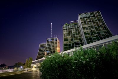 Low angle view of illuminated buildings against sky at night