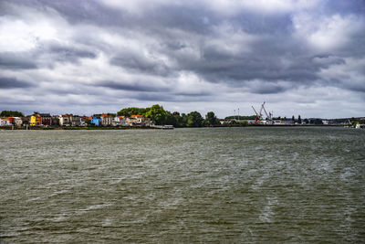 Buildings by sea against sky in city