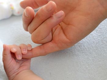 Mother holding babys hand