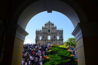 Group of people in historic building against sky