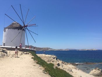 People on beach against clear sky