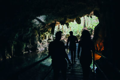 Silhouette people standing in tunnel