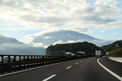 Empty road against cloudy sky