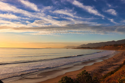 Scenic view of beach against sky during sunset