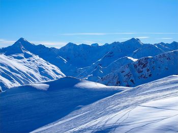 Scenic view of snowcapped mountains against clear blue sky