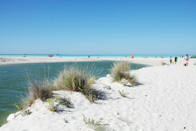 Scenic view of beach against clear blue sky