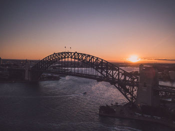 Silhouette of bridge over sea during sunset