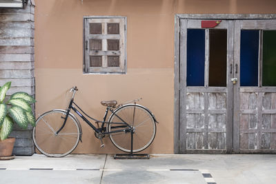 Bicycle parked against wall of building