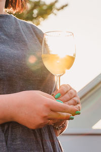 Midsection of woman drinking glass