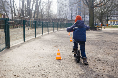 Boy riding scooter at park on sunny day