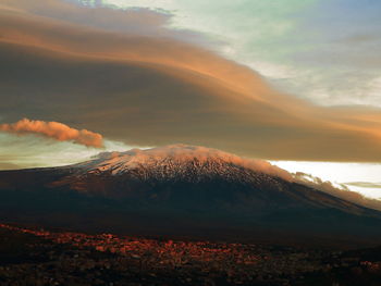 Scenic view of lenticular cloud over mountain against sky during sunset